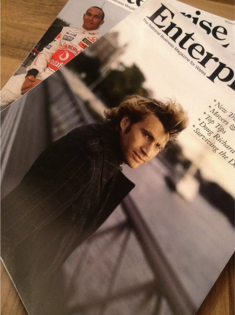 Two issues of Enterprise magazine on a wooden table